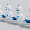 A group of white robots sitting on top of laptops